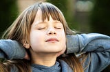 Young natural looking girl with eyes closes, feeling the sun on her pale skin hands behind her head, dreaming.