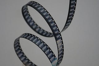 Celluloid film looping downward, against a gray background