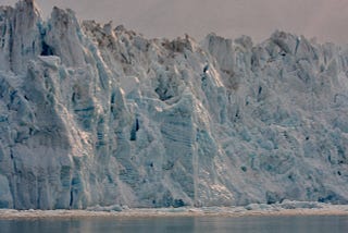 A wall of snow-covered rock lines an Alaskan cliff