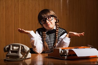 girl dressed as a boss shrugging to represent how being a little bossy can make you a better leader