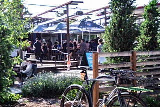 Photo of patrons sitting on a patio of a pub.