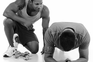 Image of 2 guys in casual fitness clothes spotting each other, training