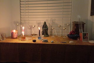 A pagan alter with candles and a statue