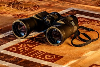 Binoculars lying on a colorful mat