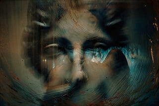 A woman’s eyes gaze through a smeared, blue and black painted glass surface, evoking the fragmented surrealism of a dream.