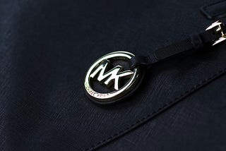 Black Michael Kors bag with a silver colored logo on the MK.