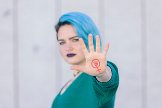 A women showing the feminism symbol on her hand.