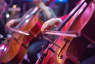 Performers play the cello at a concert.