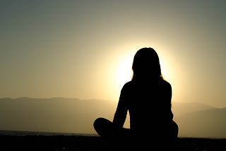 Woman meditating outdoors.