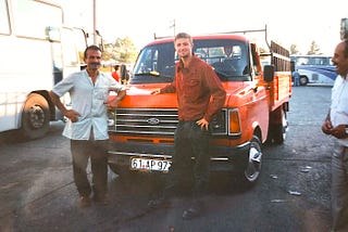 A truck driver and Gentry Bronson in front of a red truck in Turkey in 1995