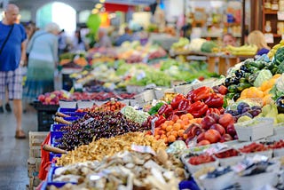 People shopping in a produce aisle.