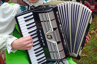 woman in German attire plays accordion