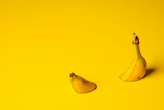 a banana submerged on a yellow background with the 2 ends protruding