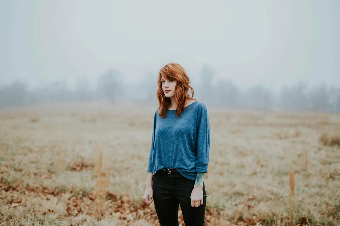 A woman stands alone in a wheat field