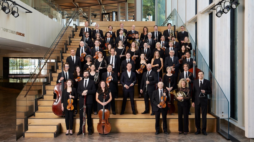 Les membres de l'Orchestre du CNA se tiennent en six rangs sur un escalier.