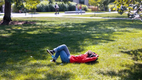 A student soaks up some warm afternoon sun on the Ag Quad. 