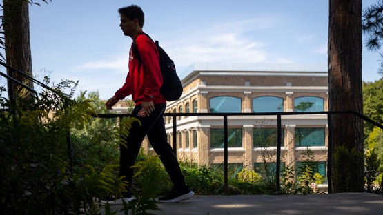 A student climbs the stairs toward Baker Lab with Rand Hall in the background.