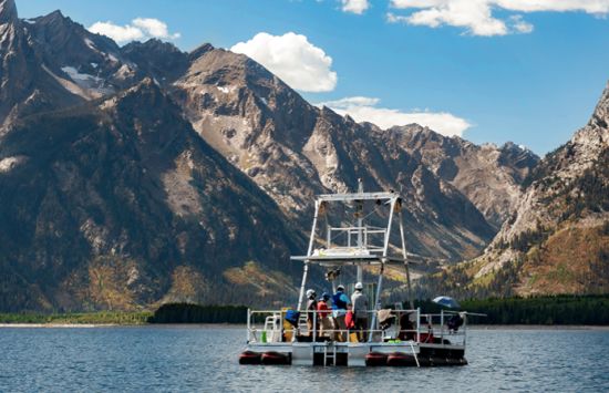 a boat in a body of water with a mountain background