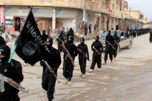 An undated photo posted to a militant website in January shows fighters from ISIL marching in Raqqa, Syria.