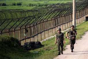 South Korean army soldiers patrol through the military wire fence near the border with North Korea.