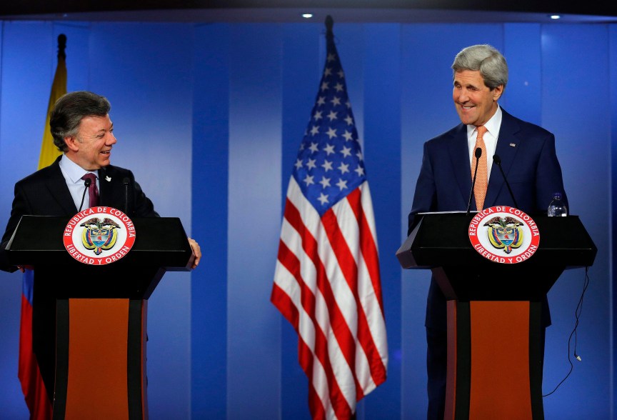 U.S. Secretary of State John Kerry (R) and Colombia's President Juan Manuel Santos smile as they address a joint news conference after their meeting at the presidential palace in Bogota December 12, 2014. REUTERS/John Vizcaino (COLOMBIA - Tags: POLITICS)