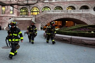 Firefighters leave the American Museum of Natural History after taming the fire.