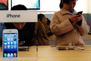 Visitors try the iPhone at an Apple Store in Beijing March 28, 2013.