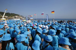 Employees of Chinese company Tiens attend a parade in Nice organized by CEO Li Jinyuan.