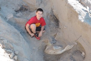 Jude Sparks with the dinosaur fossil.