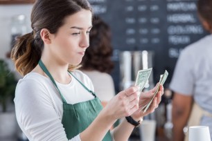 A young barista counts her tips