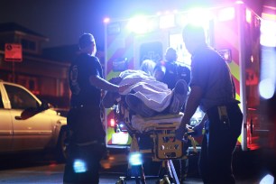 Chicago Fire Dept. paramedics transport a 20-year-old gunshot victim from the scene.