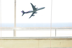 airport window with plane flying