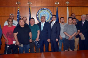 Eric Gonzalez Brooklyn DA and Mark G. Peters, DOI Commissioner, pose with the group of construction workers after handing out checks