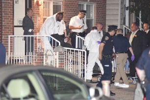 A medical examiner removes one of the four bodies of the victims of the fatal shooting.