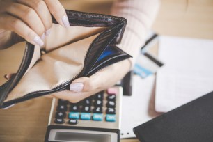 Woman holding open empty wallet.