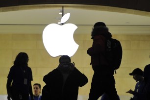 People walk past the Apple logo at the Apple Store at Grand Central Terminal in New York.