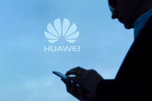 A visitor uses his mobile phone at the Huawei stand.