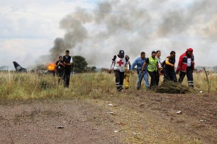 Red Cross workers and rescue workers carry an injured person on a stretcher.