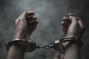 A stock photo of a woman's hands handcuffed