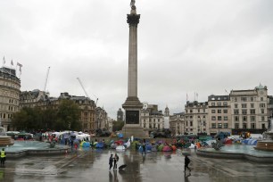 Protestors of the environmental activist group extinction rebellion camp during a demonstration during a rainy morning at Trafalgar Square in London.