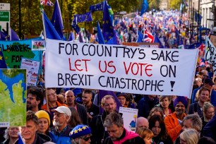 Demonstrators hold placards and EU and Union flags as they take part in a march by the People's Vote organization in central London.