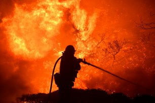 The Saddleridge fire flares up near a firefighter in Sylmar, Calif., Thursday, Oct. 10, 2019.