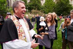 The Rev. Canon Thomas Orso blessed Stella, a 5-year-old Maltipoo carried by Jacquelyn Albano.