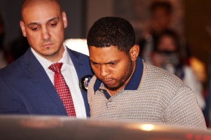 New York Police Department detectives escort Rodriguez “Randy” Santos from the NYPD’s 5th Precinct.