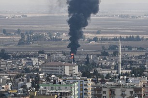 Turkish side of the border at Ceylanpinar district in Sanliurfa shows fire and smoke rising from the Syrian town of Ras al-Ain.