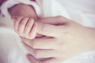 Baby hand holding mother's hand.