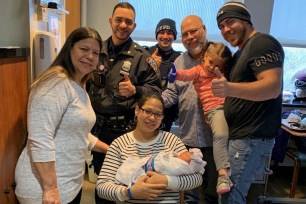 Officers Felix Sanchez and Vincent Lanzieri with Jeanette Pagan and her baby Grace Ruiz (center), Elizabeth Pagan (left), and Juan Ruiz (right) holding his other daughter Autumn Harper Ruiz, and Pedro Ruiz (back)