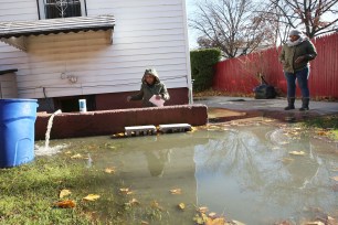 Kai Bakari with part of the Water pump pumping out water of her flooded 2 bedroom Apartment