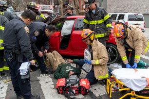 The driver is lying on the ground in front of his vehicle.