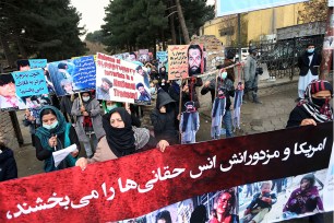 Afghan protesters carry a poster containing pictures of the recent suicide attack victims and a Farsi .